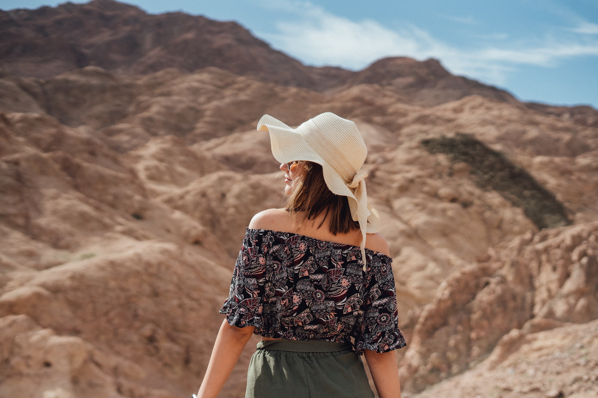 Woman in hat in Red canyon and sea in Egypt.